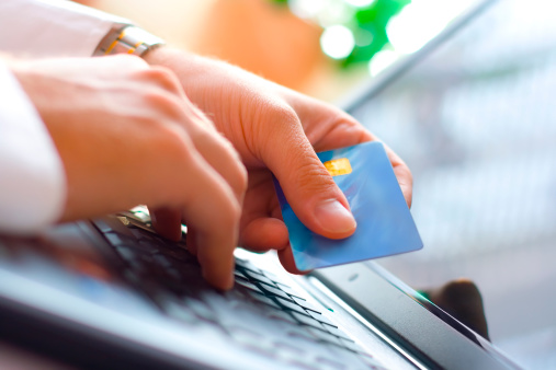 Image of hands holding a credit card and making a payment online 